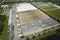 Top view of giant logistics center with many commercial trailer trucks unloading and uploading retail products for
