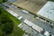 Top view of giant logistics center with many commercial trailer trucks unloading and uploading retail products for