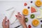 Top view of girl`s hands, placed on white desktop with fruits.