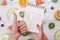 Top view of girl`s hands, placed on white desktop with fruits.