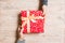 Top view of giving a present to a lovely person on wooden background. Couple congratulate each other. Festive concept. Close up