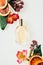 top view of glass bottle of aromatic perfume with various flowers and grapefruit slices