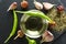 Top view of glass bowl of oil, green and dry pepper, seasoning, garlic on the dark surface