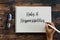 Top view of glasses and hand holding pen writing Roles and Responsibilities on notebook on wooden background