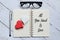 Top view of glasses,wooden heart,pen and notebook written with All You Need Is Love.Advice and motivation.