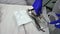 Top view gloved hands of a dentist carrying away a tray with used stainless steel dental instruments