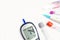 Top view glucose meter machine and numbers of glucose in the blood show on screen with sheet check