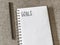 Top view goals list with notebook, pencil on fabric. Flat lay, c