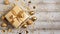 top view of a golden wrapped present with bow on a rustic old table with confetti