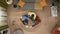 Top view of grandmother her daughter and kid sitting on the floor in the apartment room playing with colorful child