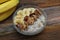 Top view of a Granola Bowl, Muesli with Oats, Nuts and Dried Fruit on Wooden table. Bannana, nuts, fruits. Healthy Breakfast. Diet