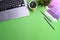 Top view of graphic designer workspace with laptop, color swatches, coffee cup and notebook on green background.