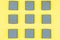 Top view of gray bulk boxes on a yellow background. Color of the year 2021
