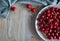 Top view on the gray plate of cherries on rustic wooden background with text space