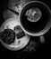 Top view grayscale of a cup of tea with lemon next to a plate with the tea bag