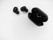 Top view grayscale of wireless earbuds with a black open powerbank on a white background