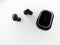 Top view grayscale of wireless earbuds and a plastic powerbank on a white background