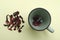 Top view of green cup and hibiscus tea flowers on the yellow background