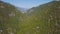 Top view of green mountains flowing into each other. Clip. Beautiful mountains covered with green trees on summer day