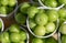 Top view of green plums or greengage in paper cup on sale in the street in Turkey, popular spring fruits with a very sharp sour