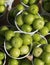 Top view of green plums or greengage in paper cup on sale in the street in Turkey, popular spring fruits with a very sharp sour