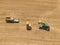 Top view of green tractor loading straw bales on a trailer