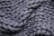 Top view of grey chunky knit blanket as background