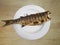 Top view of grilled Mullet fish on a white plate