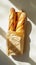 Top view of group of crispy baguettes in paper bag against white background with aesthetic shadows. Generative AI