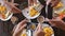 Top view of a group of friends having breakfast in a cafe at wooden table, taking picture of omelette, toasts and coffee