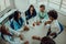 Top view of a group of multiethnic medical professionals including doctors, surgeons, and nurses are gathered in a