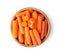 Top view of a group of organic small baby carrots in wood bowl isolated