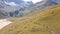 Top view of group of tourists walking along mountain path. Clip. Climbers walk along foothills trail with yellow grass