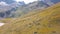 Top view of group of tourists walking along mountain path. Clip. Climbers walk along foothills trail with yellow grass