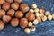 Top view of a group of whole and peeled hazelnuts on blue marble background in horizontal