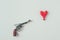 top view of gun barrel aiming at heart shaped balloon