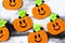 Top view of Halloween crafts, felt handmade pumpkins, black patina on white paper background