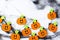 Top view of Halloween crafts, felt handmade pumpkins, black patina on white paper background with copy space for text