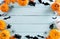 Top view of Halloween crafts, orange pumpkin, ghost, bat and spider on  pastel wooden background with copy space for text.