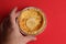 Top view of a hand golding meat pie isolated on a red background