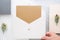Top view of hand holding blank gold card in white envelop with p
