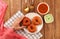 Top view of a hand holding a South Indian Medu vada on a plate served with sauces