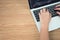 The top view of the hand that uses the laptop creates some information on the wooden table. With the copy area on the left