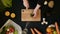 Top view handle shot of young woman cutting fresh vegetables on wooden board