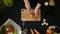 Top view handle shot of young woman cutting fresh vegetables on wooden board