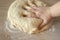 Top view on the hands of a cook who kneads yeast dough for baking
