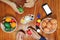 Top view of hands of family members are painting eggs with a paintbrush on wooden table for preparing Easter day. Happy family ti