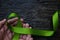 Top view of hands holding lime green color ribbon on dark background. Non-hodgkin lymphoma cancer, lyme disease.