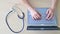 Top view of hands on the keyboard. Woman doctor at the desk typing on a laptop. A nurse fills out a patients electronic