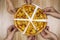 Top view of hands taking slices of delicious and crispy hawaiian pizza. Group of hungry friends sharing delicious lunch on wooden